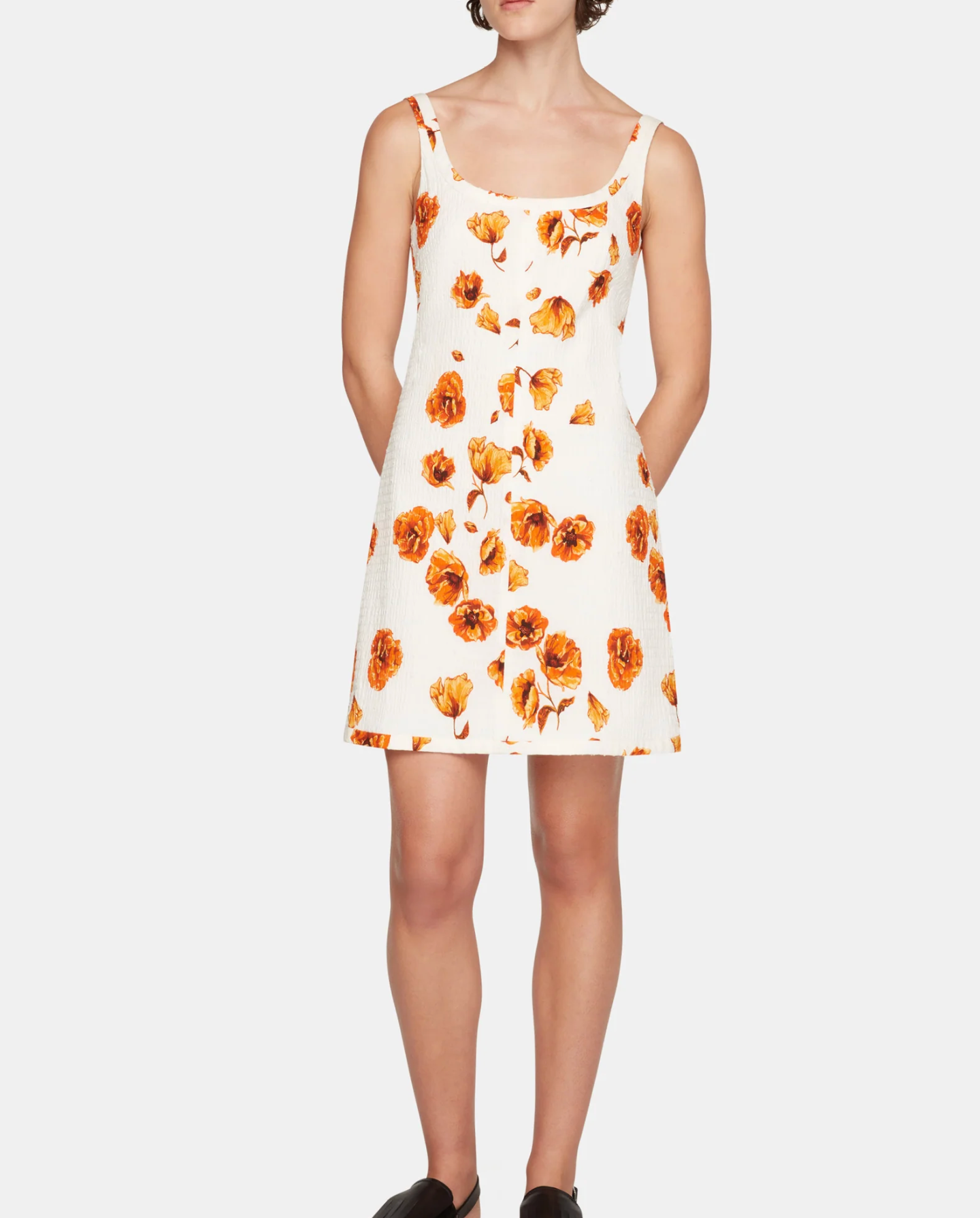 Woman wearing a floral dress with orange flowers on a white background