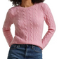 Woman wearing a pink cable knit sweater and blue jeans on a white background