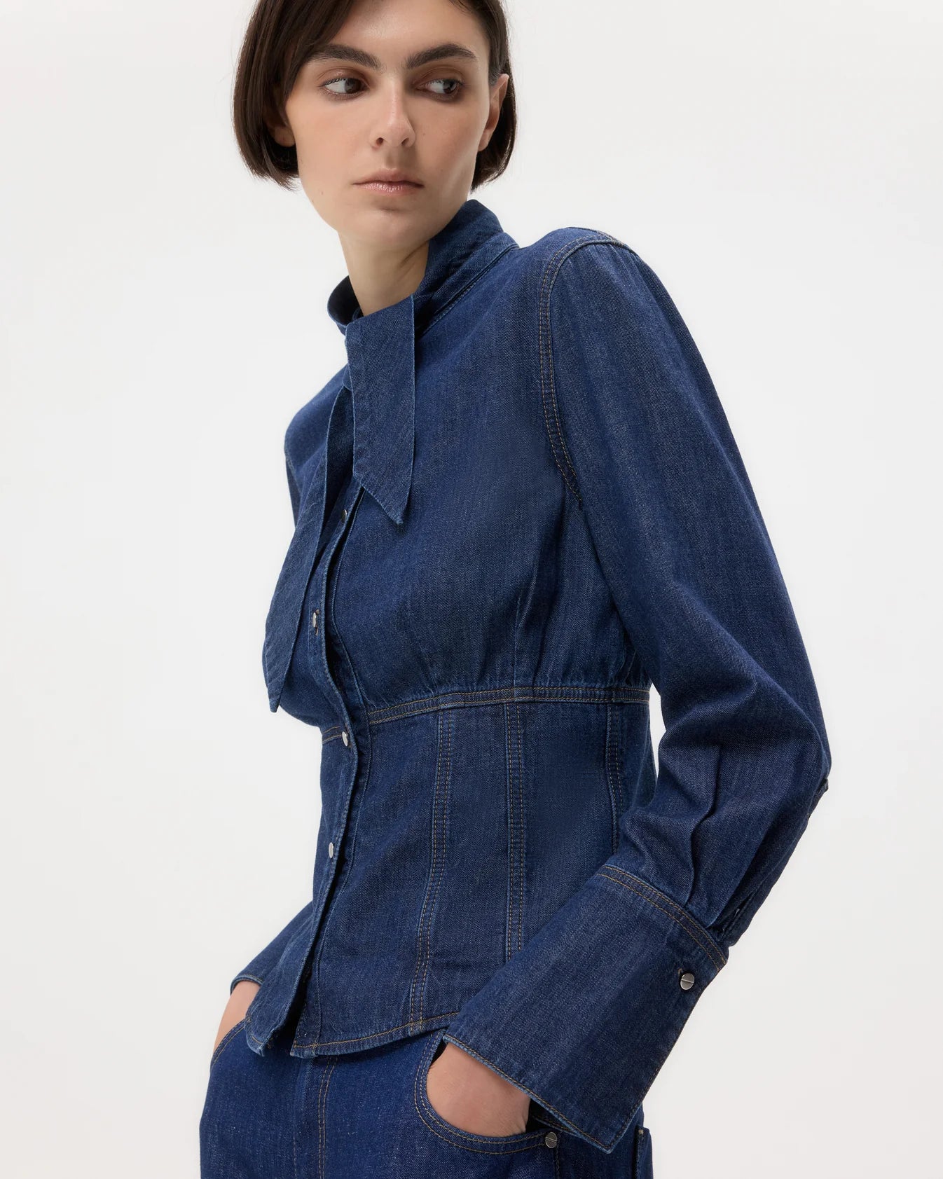 Woman wearing a blue denim jacket on a white background