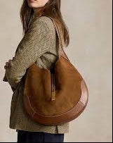 Woman holding a brown leather bag against a beige background