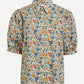A short-sleeve button-up shirt with a dense, multicolor floral and botanical print on a light cream background, featuring puff sleeves and a pointed collar.